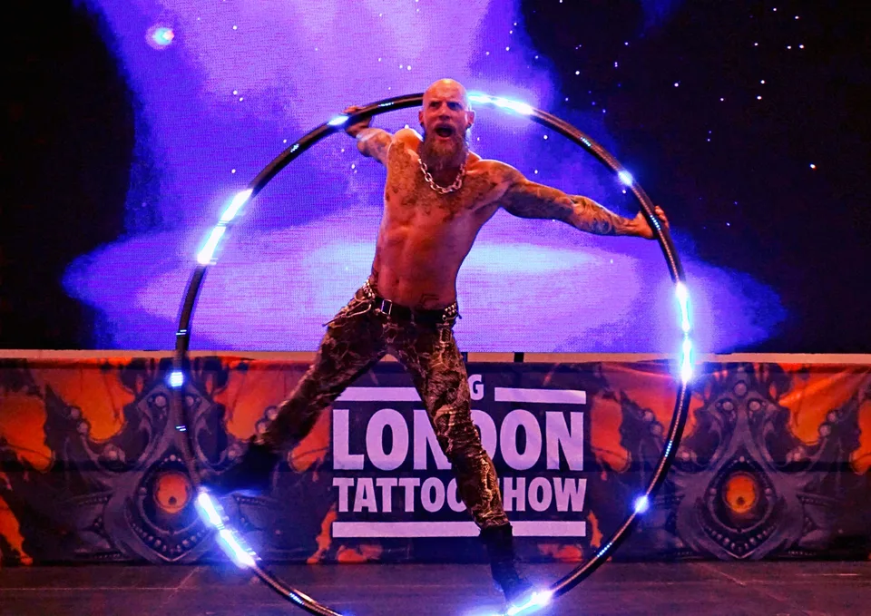 Performer balancing an illuminated hoop on stage