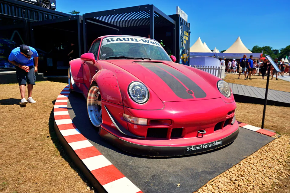 Red wide-bodied Porsche at an outdoor show